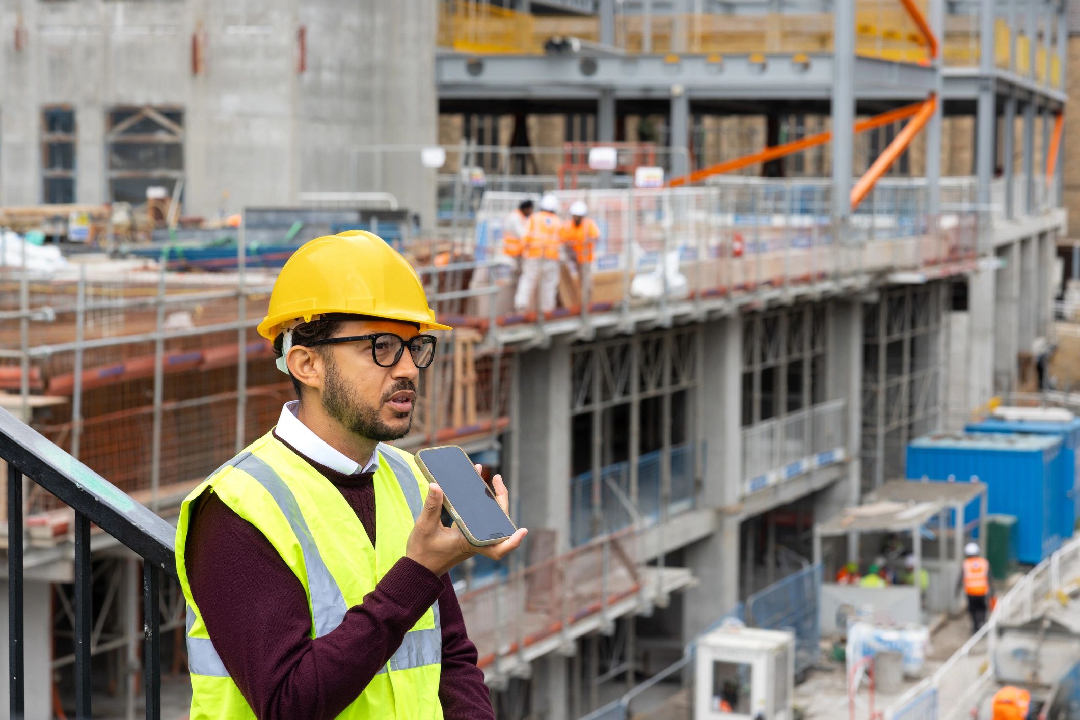 Construction professional at a building site with a tablet