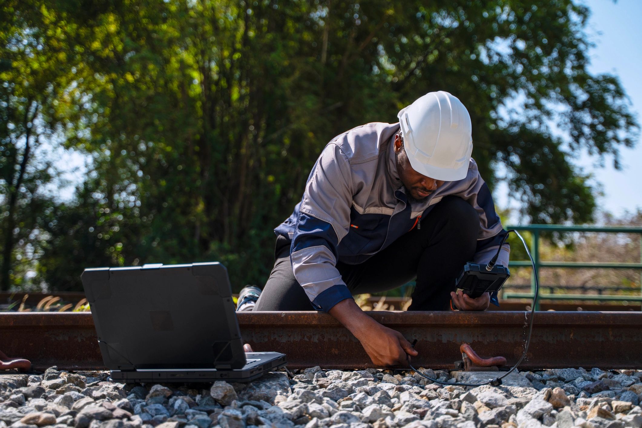 Engineer inspecting railway infrastructure with a measurement tool
